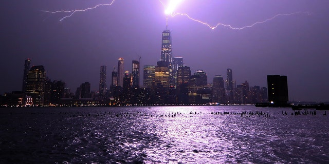 Lightning lights up the sky over Lower Manhattan as a bolt strikes One World Trade Center on August 22, 2017, as seen from Hoboken, N.J.