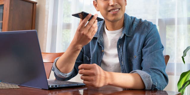 Young mexican latinx man using laptop and smartphone (iStock)
