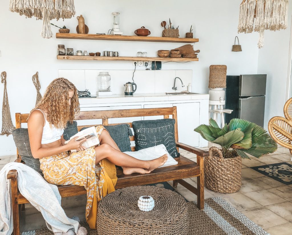 Bohemian dressed Woman relaxing in the living room reading a book