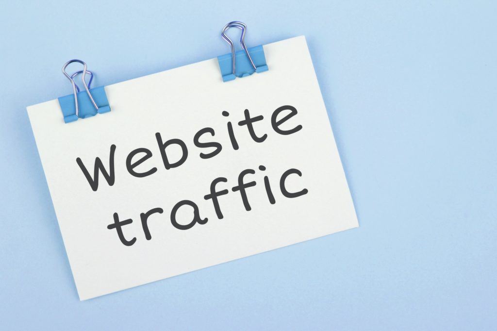 Inscription Website traffic. Note written on a white sticker with paper clip.