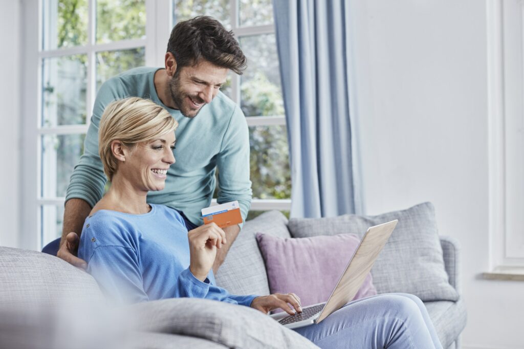 Happy couple at home shopping online