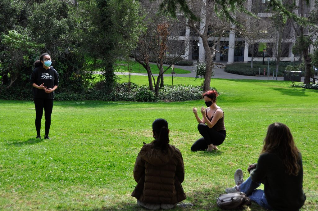 Cast members of 'Our Monologues' rehearse outdoors with masks as directors Risa Sundu and Rusma Kharel observe.