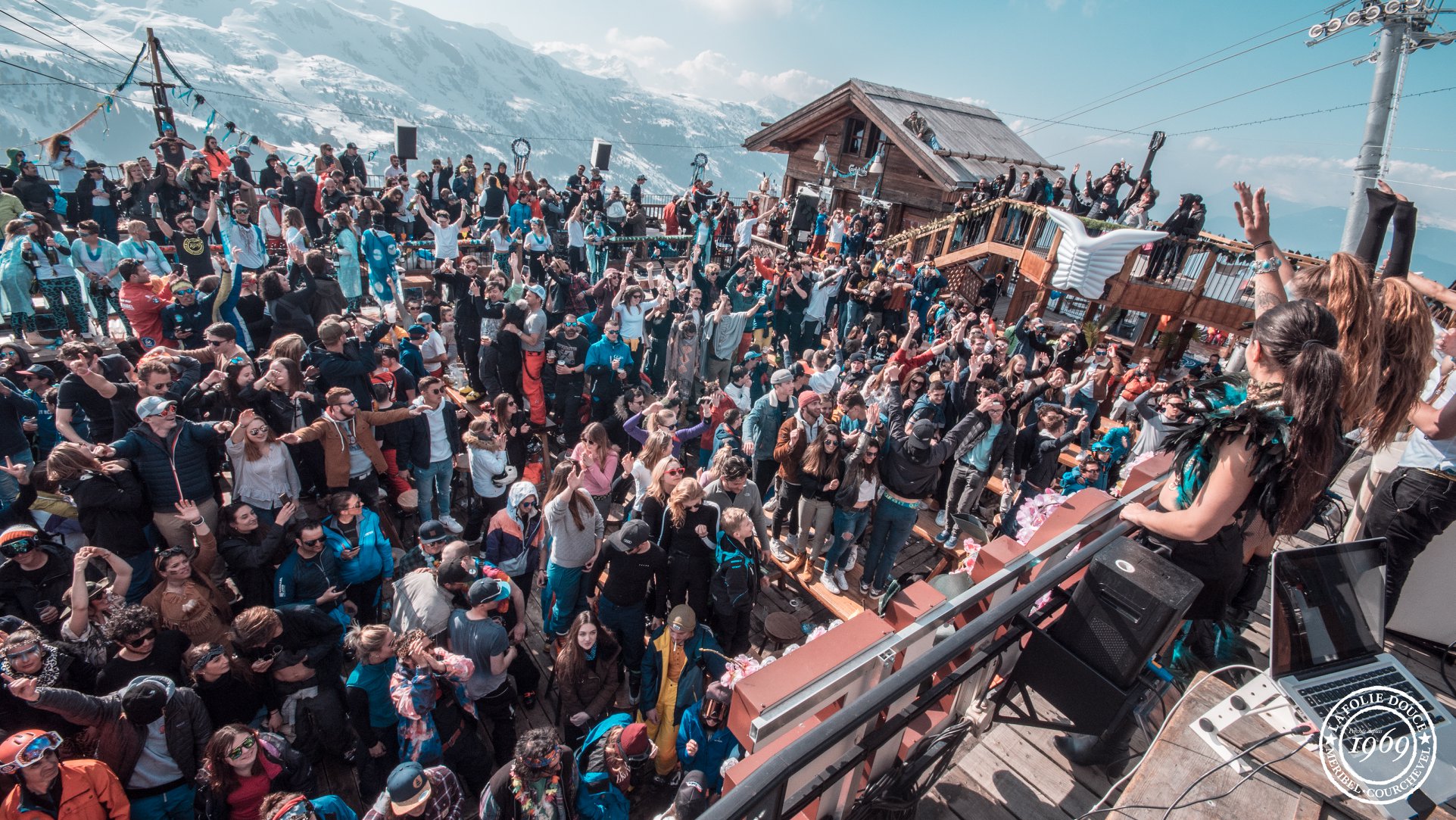 large crowd partying outdoors in the mountains at folie douce meribel