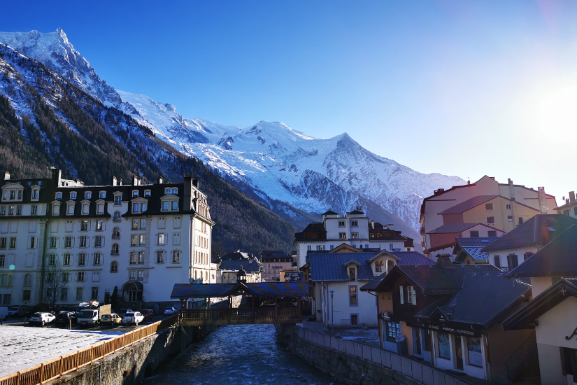A captivating view of Chamonix, nestled in the Mont Blanc massif, showcasing the iconic Alpine town surrounded by snow-covered peaks. Skiers and snowboarders enjoy the slopes, highlighting the dynamic winter atmosphere and the thrill of alpine adventure in this renowned ski destination.