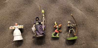 4 minis, a barmaid, warlock, tribal warrior, and skeleton archer