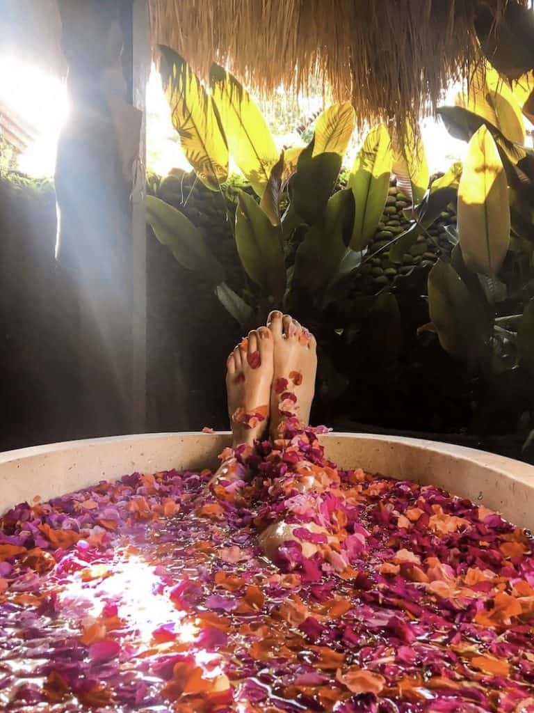 girl relaxing in a flower bath at karsa spa in ubud, bali bucket list