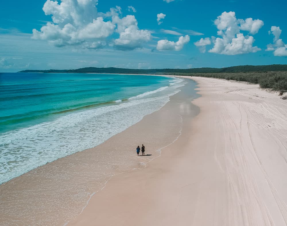 Aerial shot of couple wading in the waters of Main Beach on North Stradbroke Island