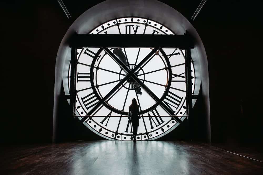 women stands in front of the the iconic musée d'Orsay clock