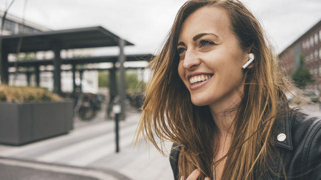 Smiling woman wearing wireless earbuds 