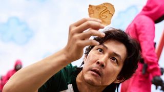 Gi-hun in Squid Game holding honeycomb candy
