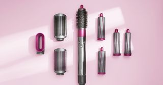Dyson Airwrap styler and attachments on pink background