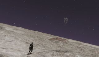 A tiny astronaut stands on a huge, barren planet