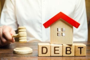 Wooden Blocks With The Word Debt And A Miniature H