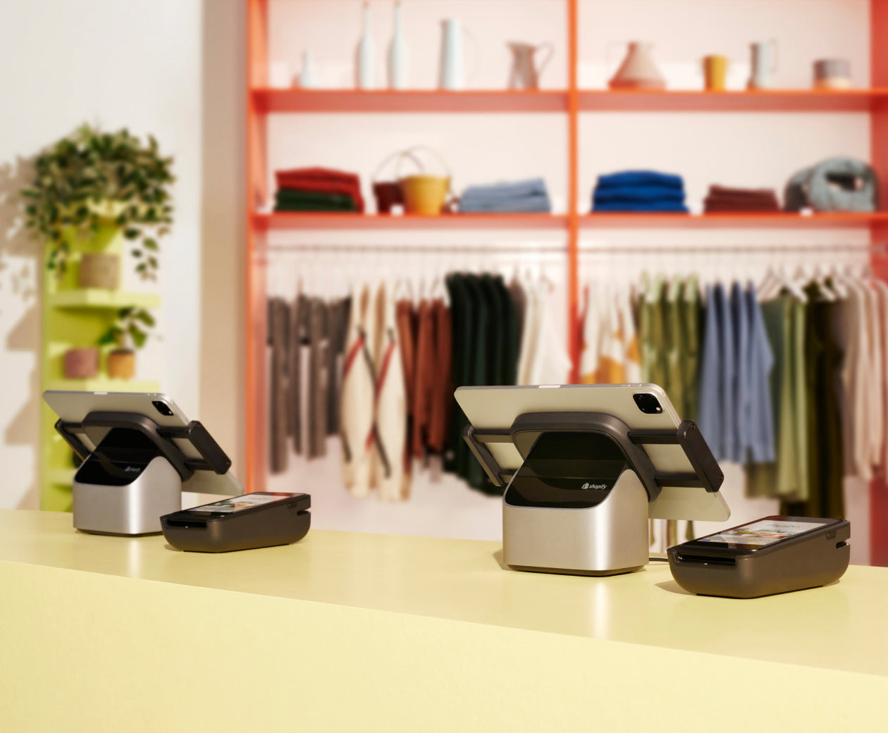 A Shopify tablet stand on a sales counter with a payment terminal next to it.