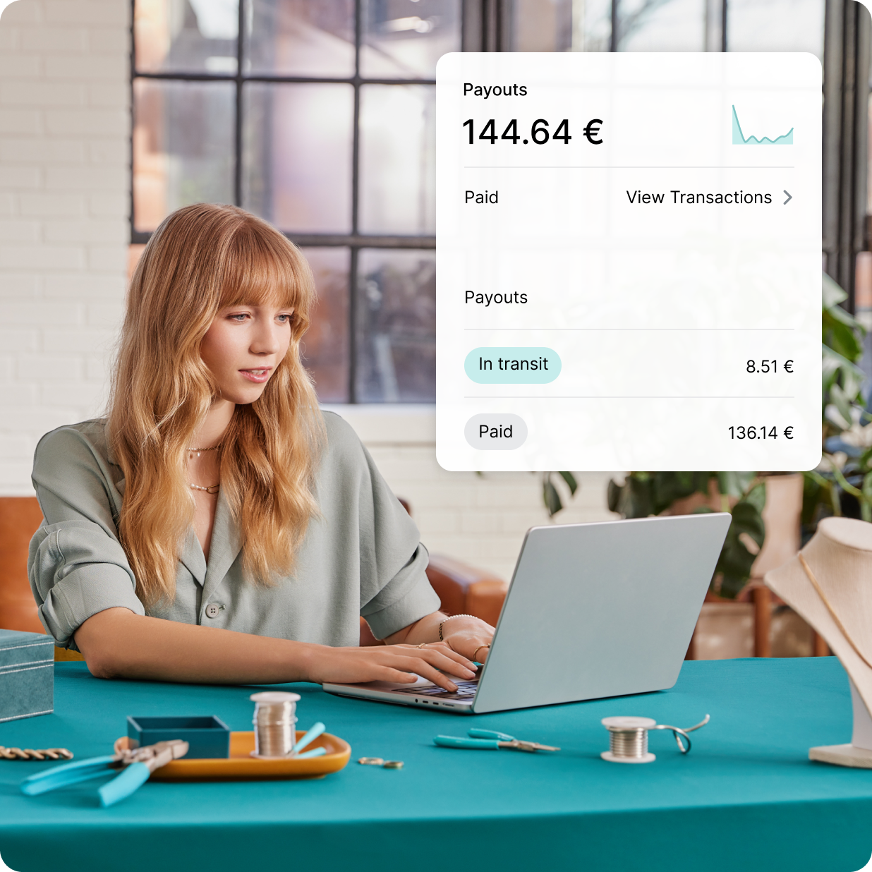 Een witte vrouw werkt op haar laptop en stelt Shopify Payments in voor haar juwelenzaak