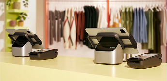 A Shopify tablet stand on a sales counter with a payment terminal next to it.