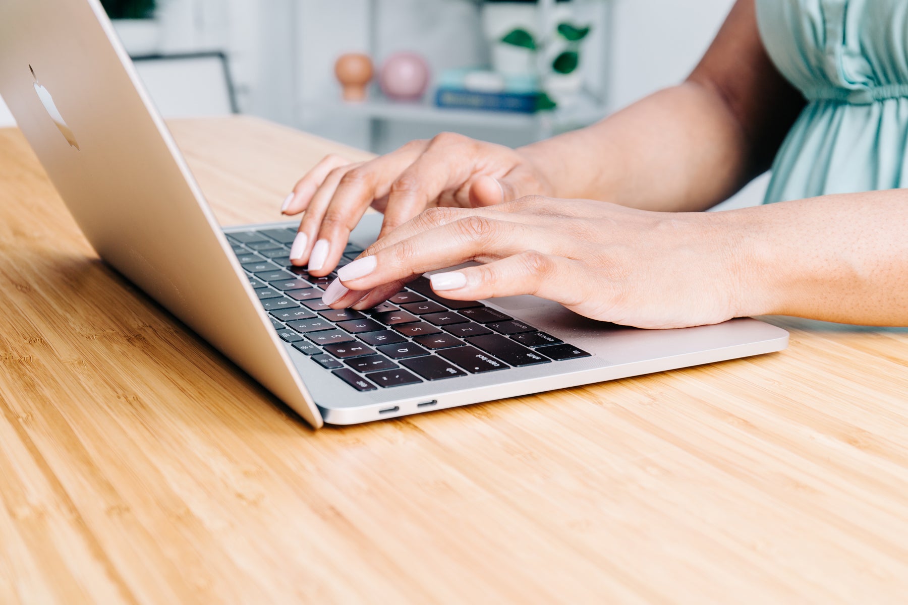 Close of a woman's hands typing on a laptop