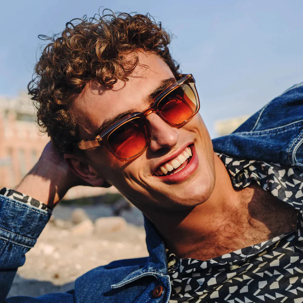 Man wearing sunglasses leans his head on his hand