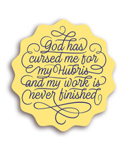 Yellow sticker with wavy edge and  "God Has Cursed Me For My Hubris And My Work Is Never Finished” in blue cursive font with swirling lines attached to parts of the text - from Polygon