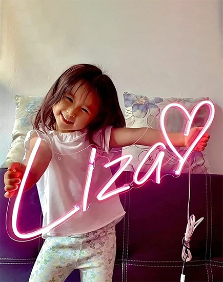 A heartwarming custom neon name sign for 'Liza' featuring a soft pink heart design—a perfect gift to show love for your child. This personalized neon sign by Lamomoneon combines the charm of neon lights with heartfelt creativity, making it a favorite among kids. 