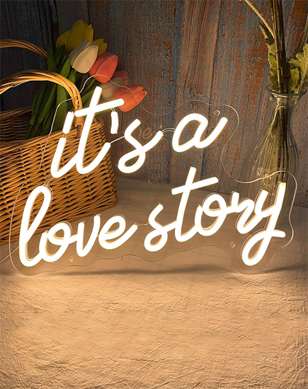 Create a warm and inviting atmosphere with this custom white text neon sign: 'It’s a Love Story.' Perfectly designed to spread good vibes, this personalized neon sign from Lamomoneon adds a touch of elegance and charm to any space.