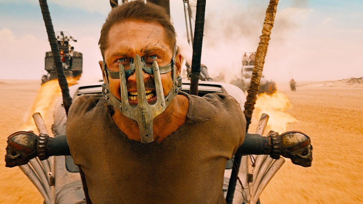 Tom Hardy wears a facemask at the head of a vehicle in Mad Max: Fury Road.