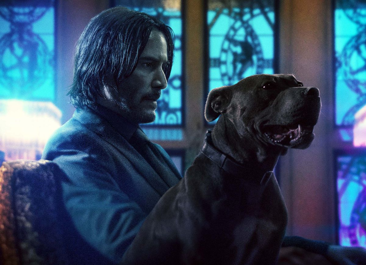 John Wick (Keanu Reeves) with a dog.