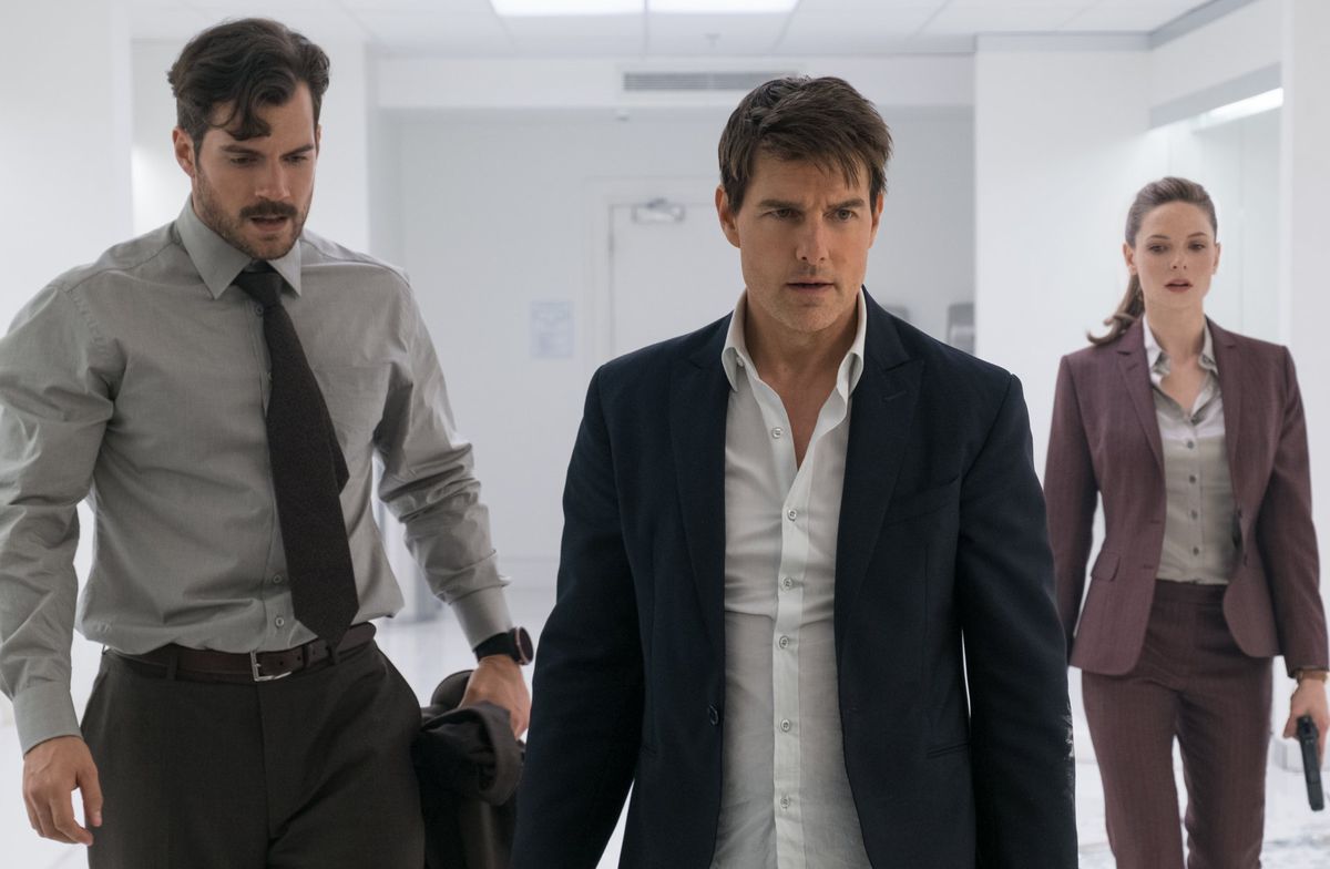 henry cavill, tom cruise, and rebecca ferguson wear nice outfits and walk in a white room in mission impossible fallout