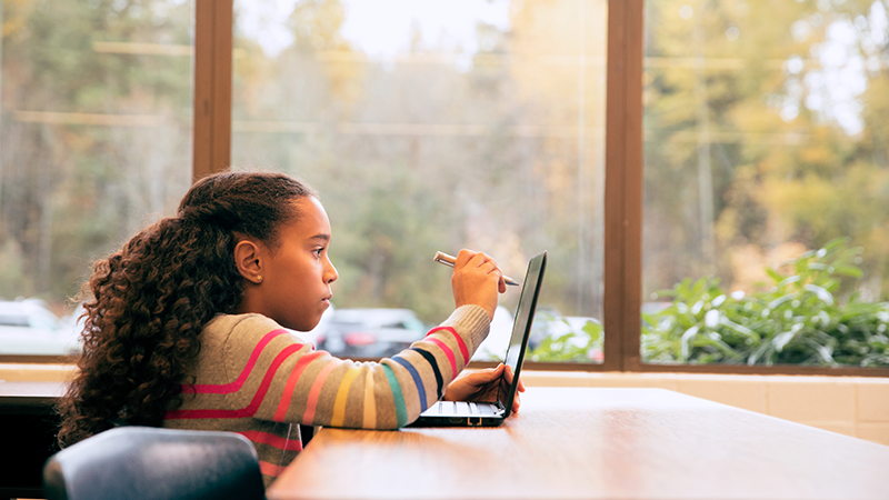 Young girl student working on a laptop