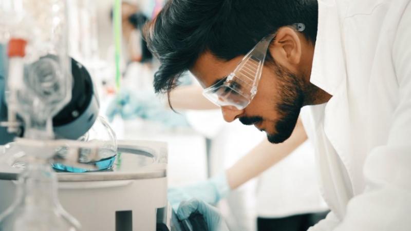 A scientist wears safety glasses while conducting an expirment