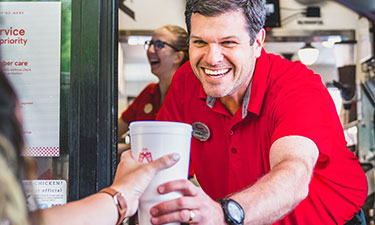 Chick-fil-A® Team Member handing drink out Drive-Thru window