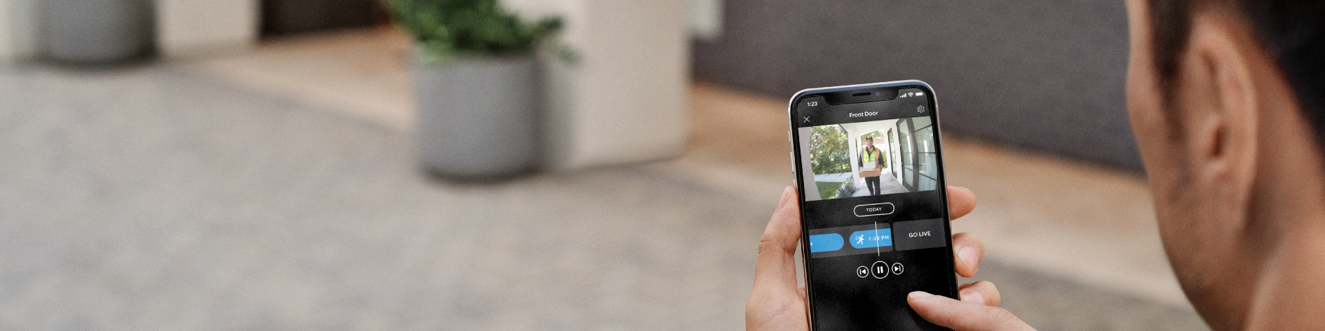 A homeowner reviewing a video in the Ring app of a package being delivered at their doorstep