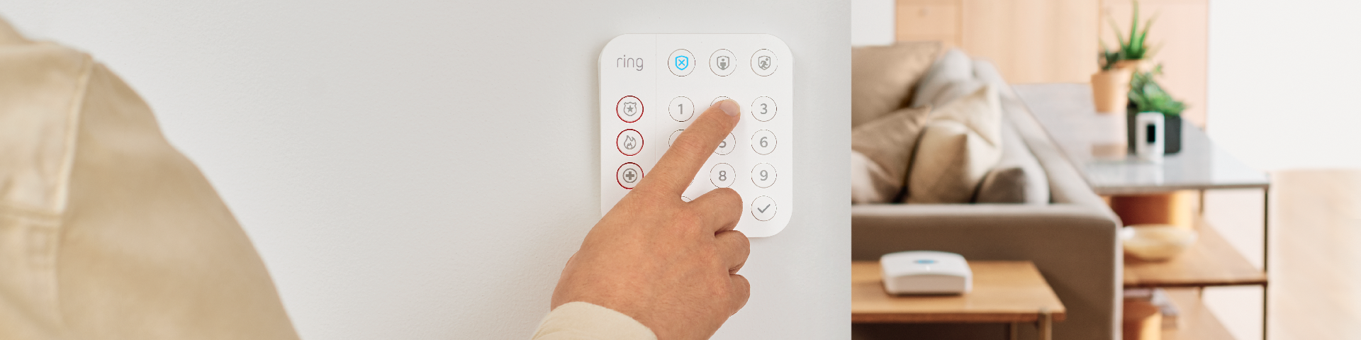 A homeowner pressing in a passcode on Ring Alarm Keypad (2nd Gen)  inside their home.