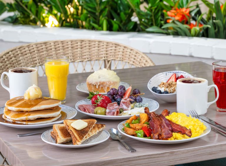 A Table With Plates Of Food And Drinks On It