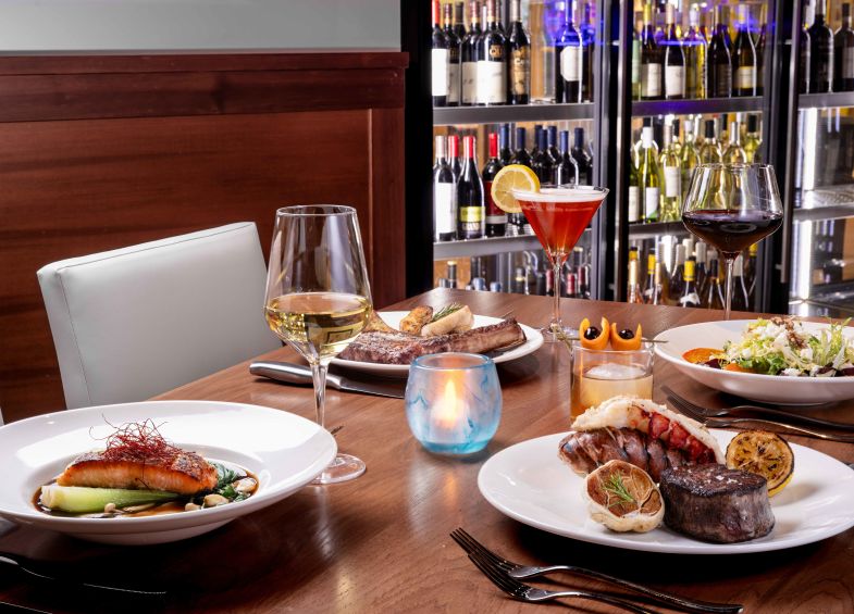 A Table With Plates Of Food And Glasses Of Wine