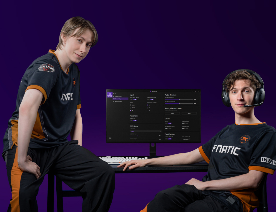 A promotional photo of two FNATIC players posing with the M10S Gaming Monitor Screen with one of the players wearing on his H5 Gaming headphones.