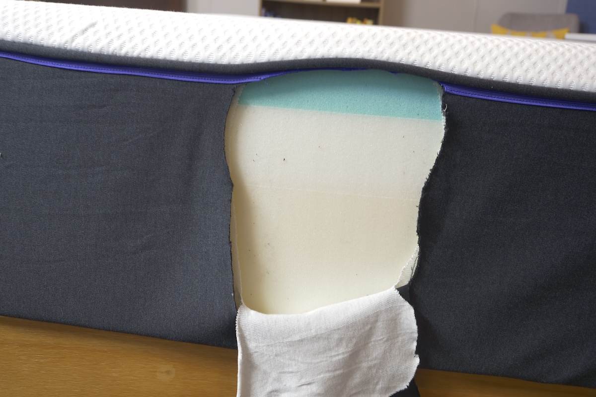 Material cut away from a mattress so that three distinct foam layers can be seen.