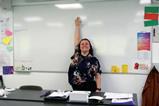 A teacher standing in front of a large whiteboard in a classroom