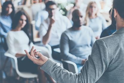 An audience sat in front of a presenter