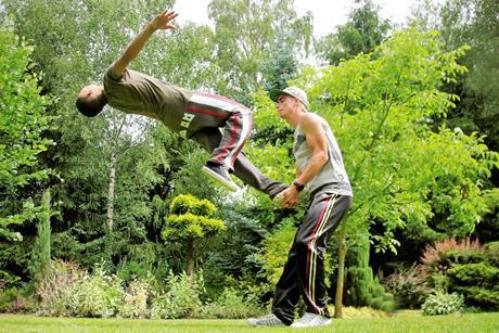 One man helping another to do a backflip