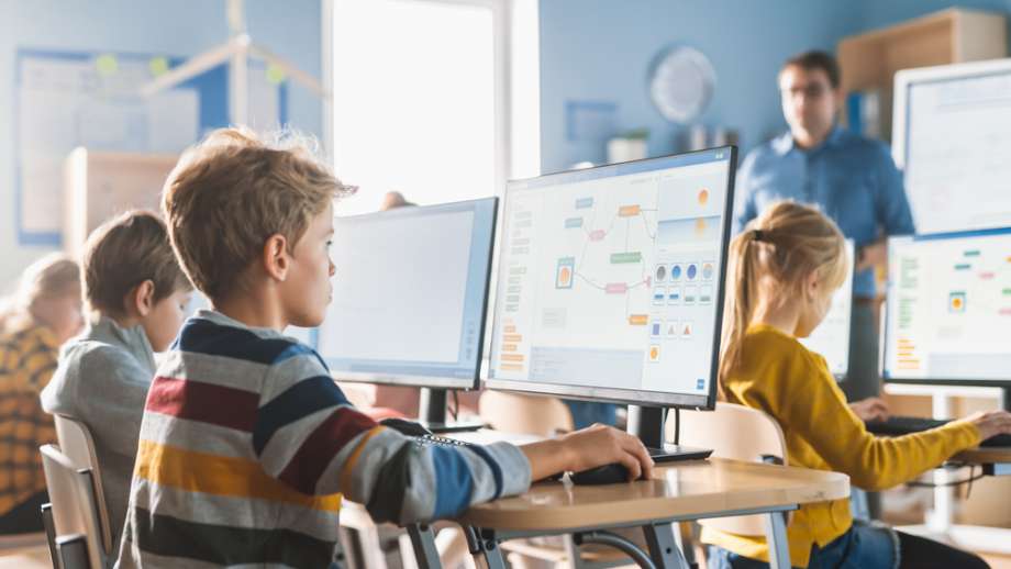 Children sit at their desks on their computers
