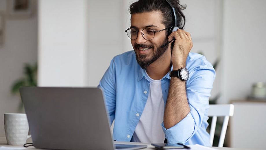 student with headset working on his laptop