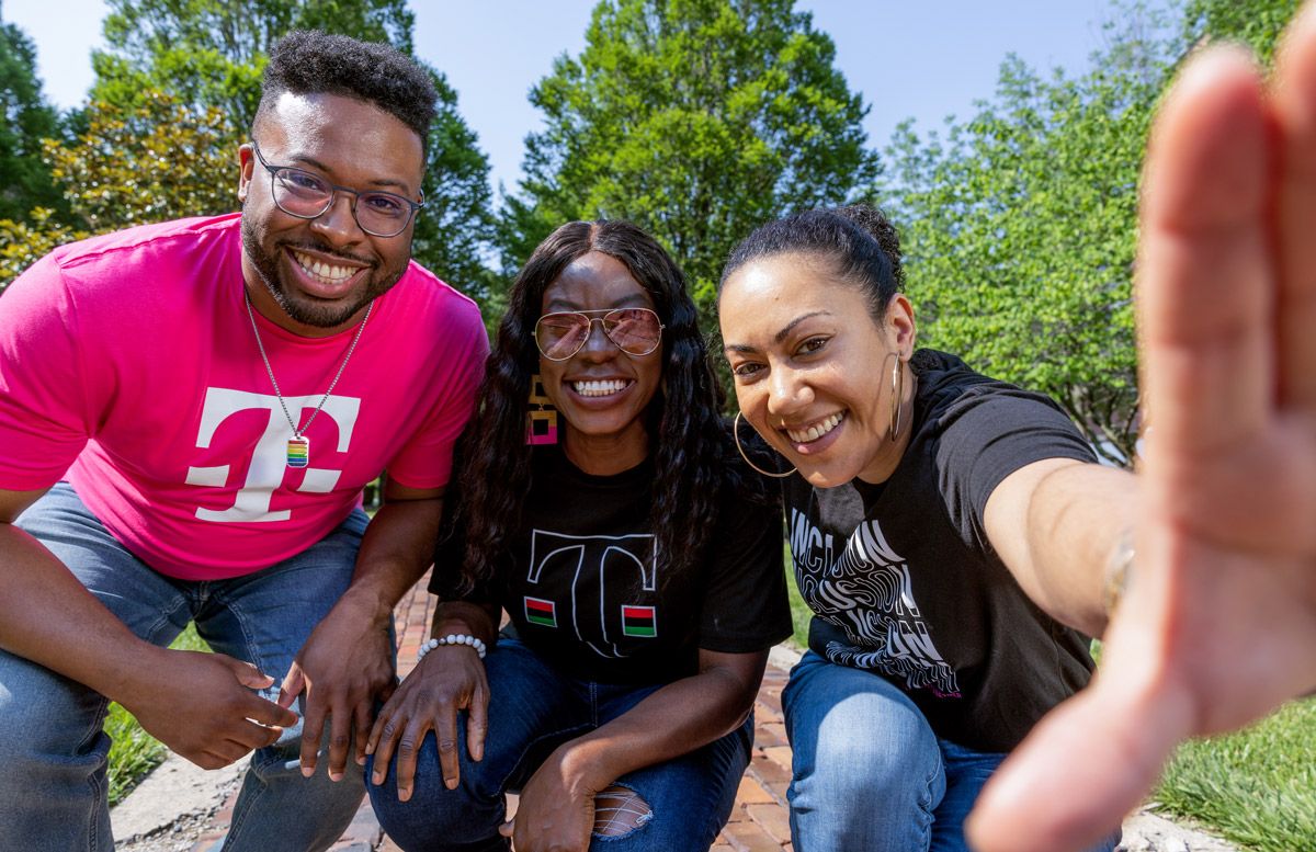 Three T-mobile employees smiling