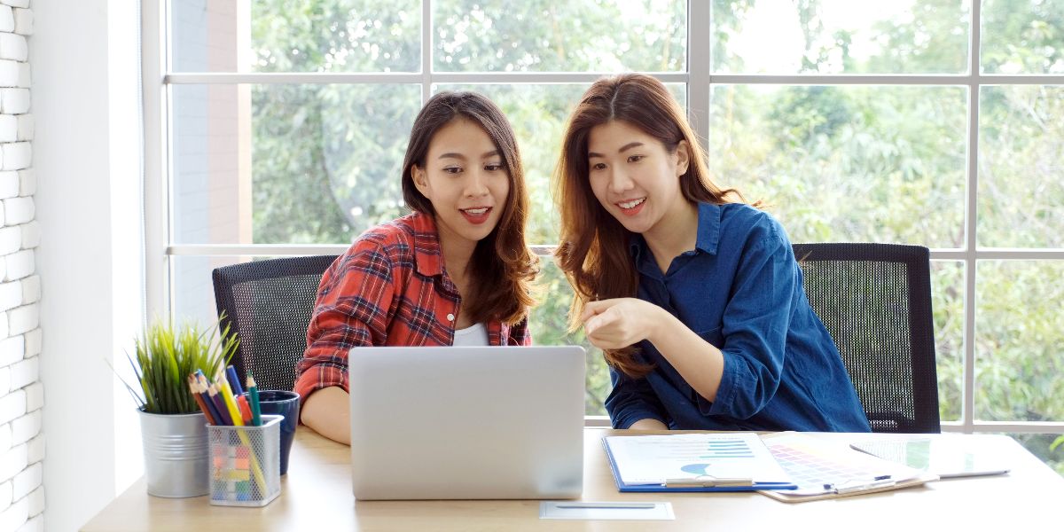 two women working on laptop