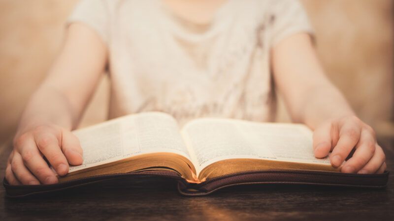 A child's hands on an open Bible. | Krystyna Taran | Dreamstime.com