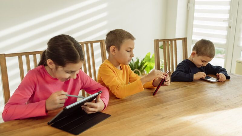 Three young children using mobile devices | 	Ok Shu/Westend61 GmbH/Newscom