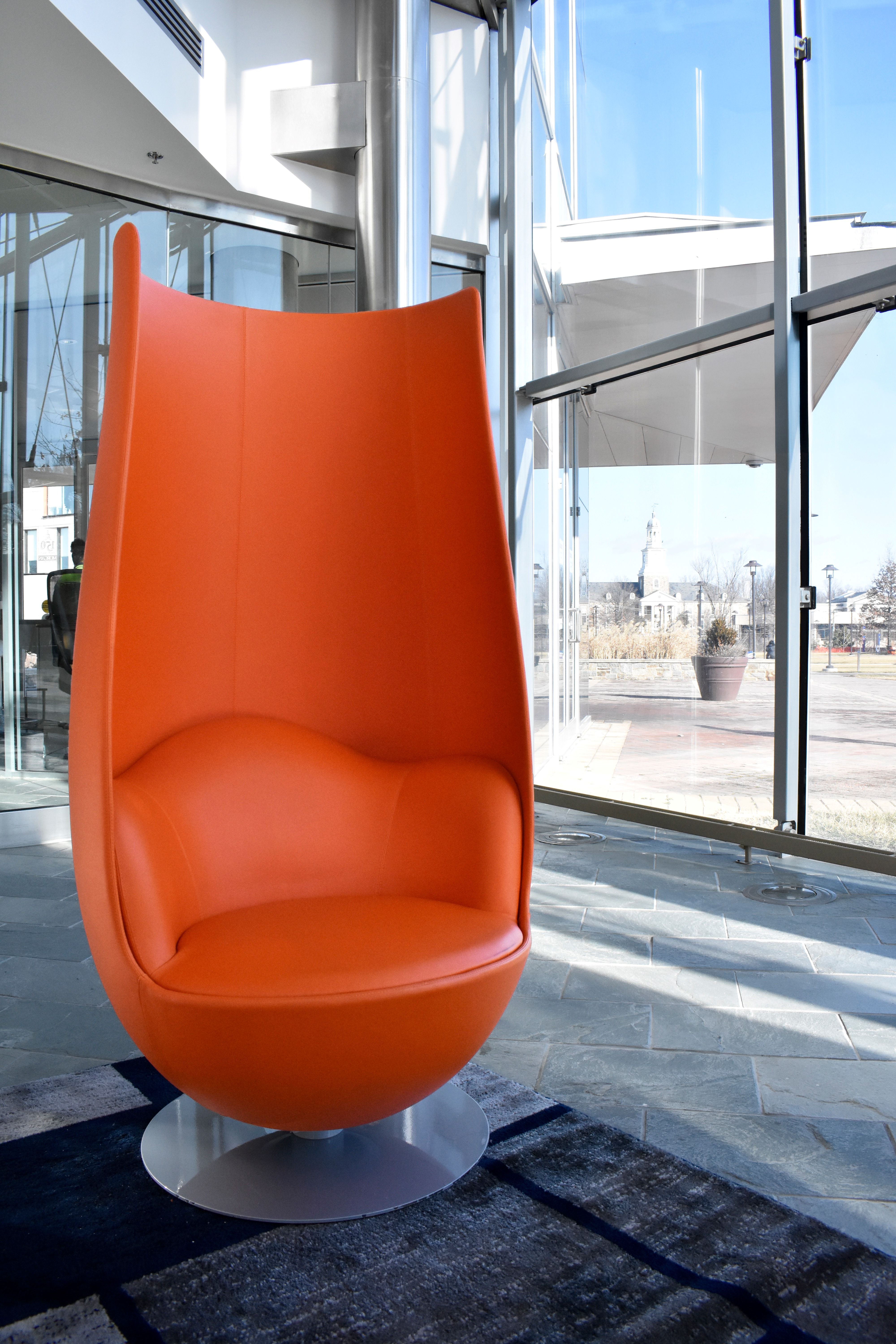 close up of orange lounge chair in front of window