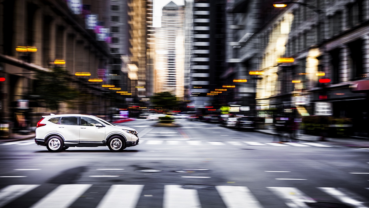 Car speeding down a road in a big city.