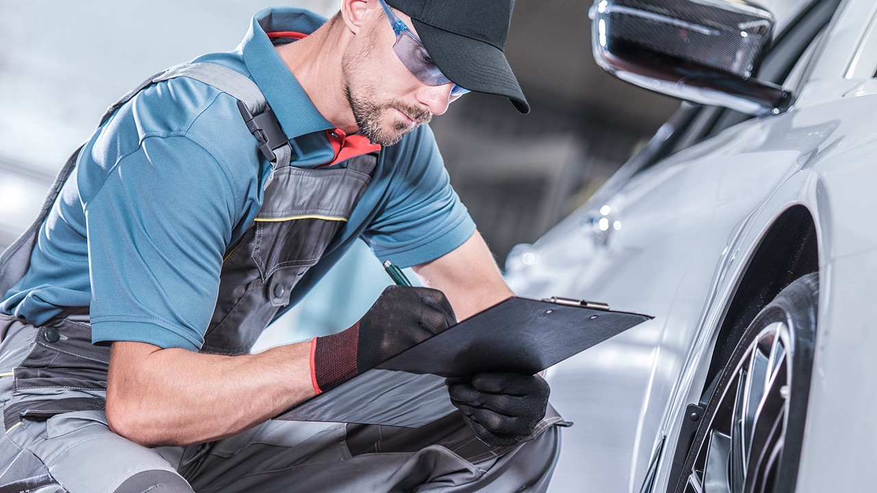 Seasonal Car Maintenance. Caucasian Auto Service Technician Looking For Potential Issues with the Serviced Vehicle.