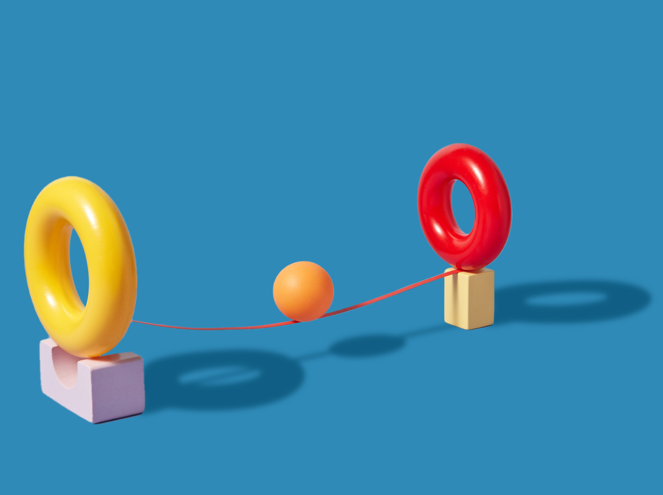 Ball balancing on string between two objects representing teamwork